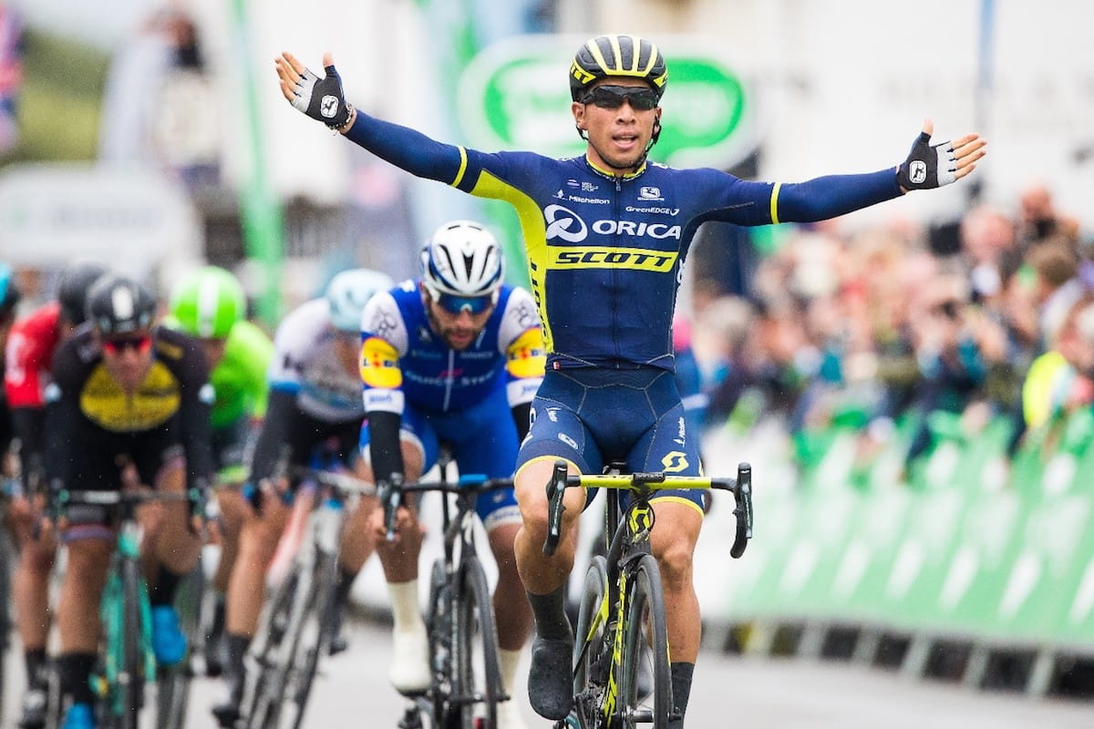 cyclists celebrates with arms in the air after crossing the line in first place