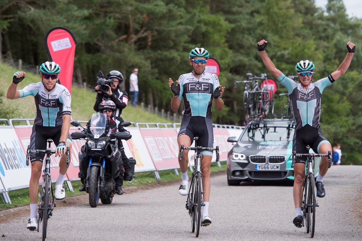 cycling teammates celebrate crossing the line together