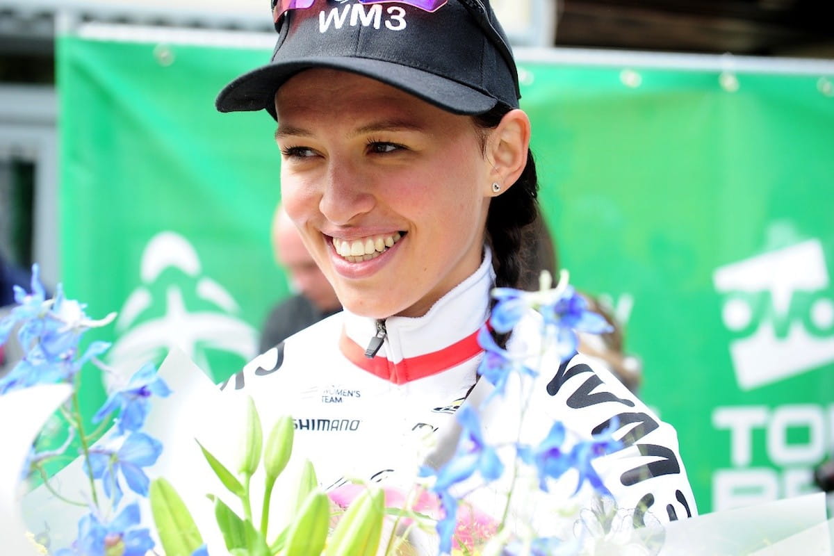 cycling race winner smiles with flowers