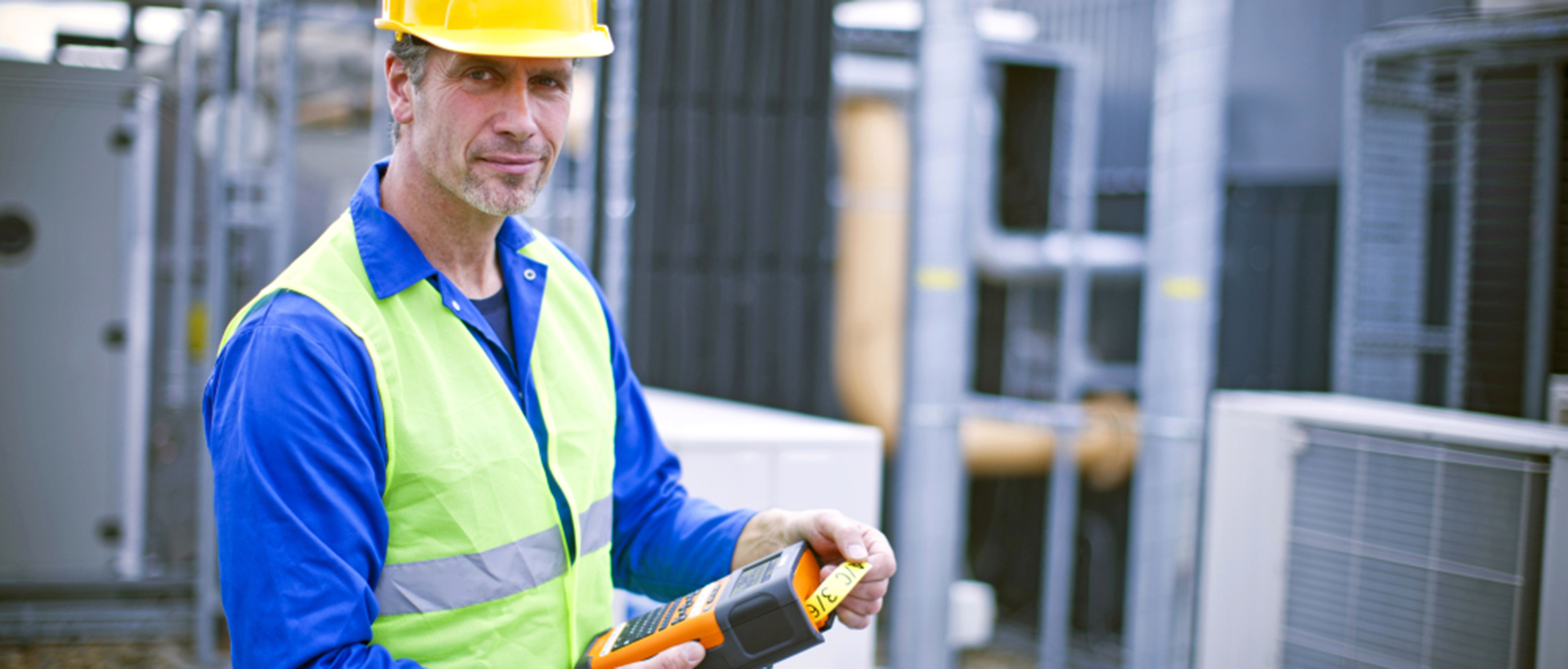 An electrician using a mobile label printer at his worksite 