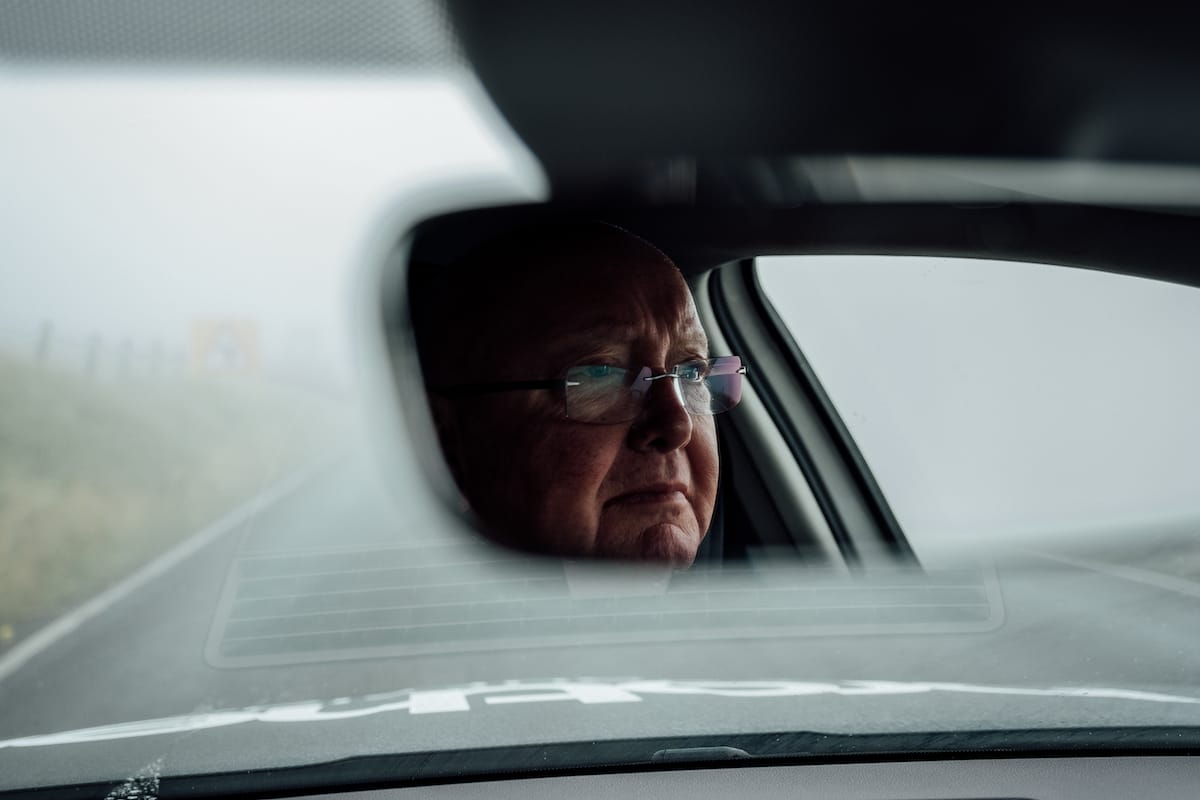 Tony Barry seen through the rear view mirror of a Neutral Service race support vehicle