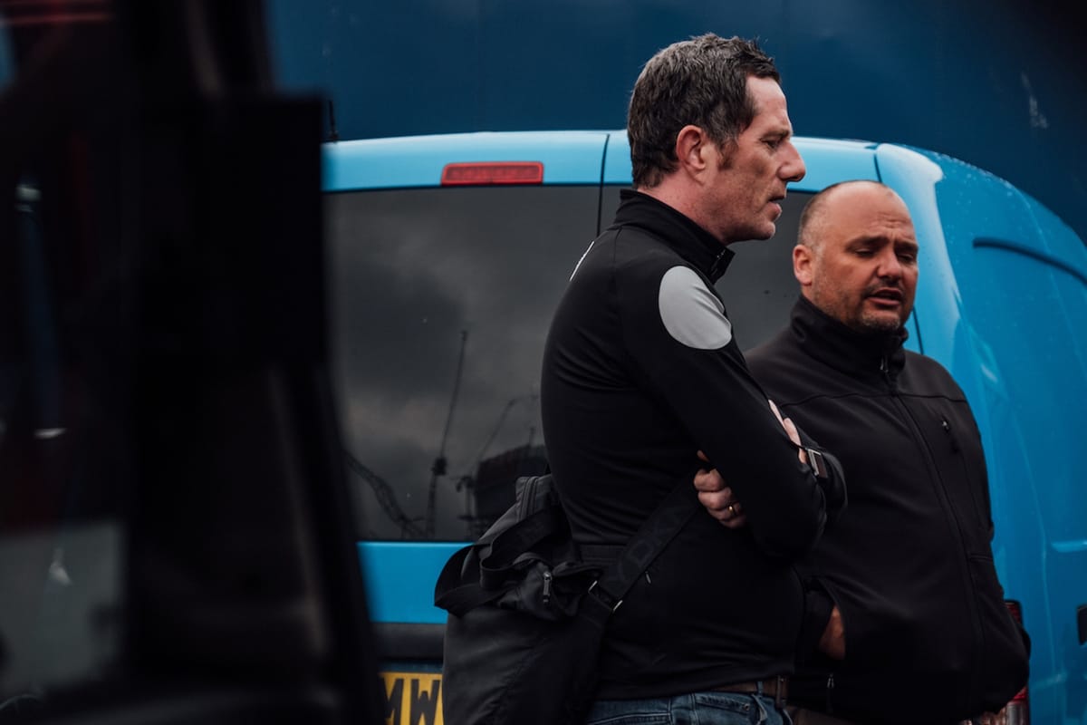 Side shot of Phil Jones MBE and Simon Howes as they are talking while stood in front of a blue van