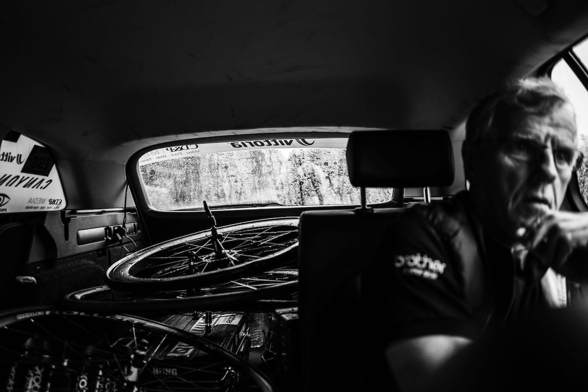 Neutral service mechanic inside support vehicle with bicycle spares in the back