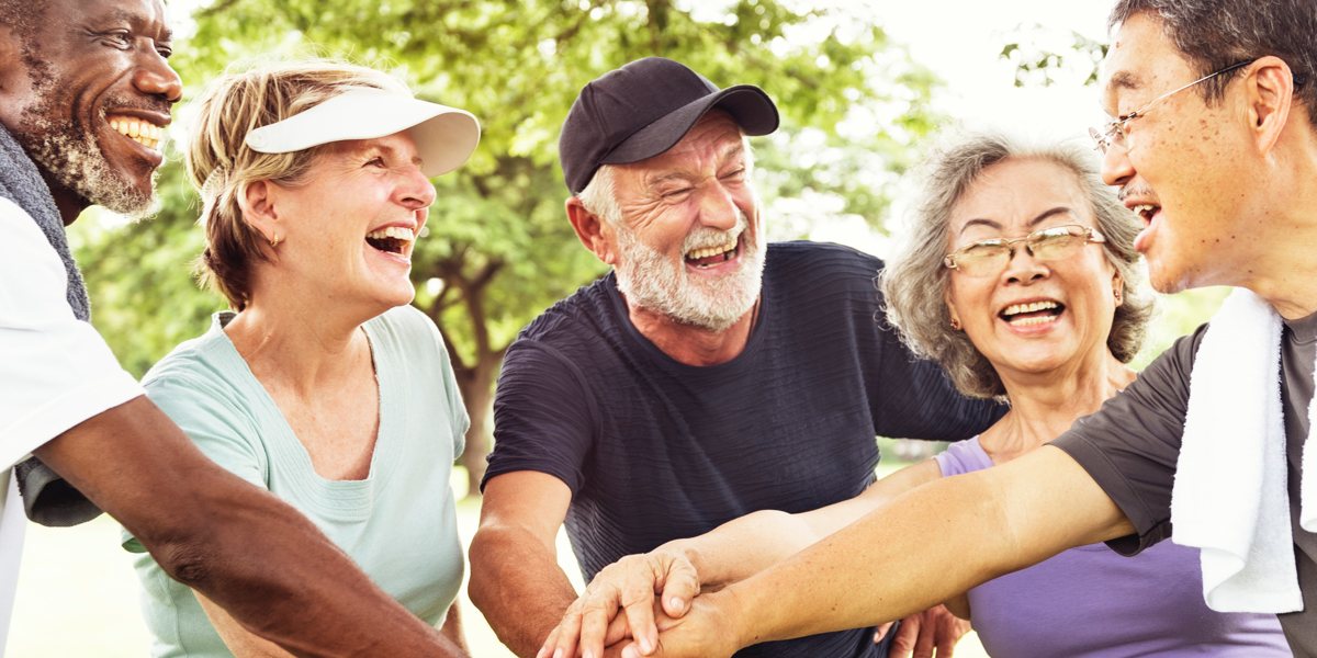 ageing people putting their hands in during a huddle