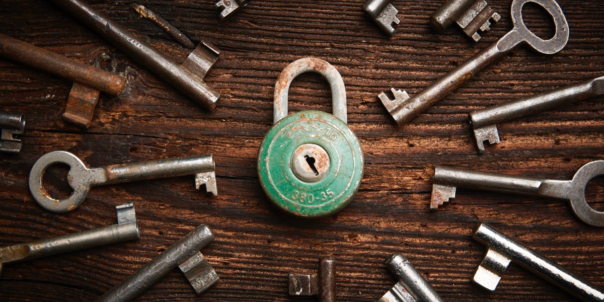 a rusty green lock surrounded by many different keys