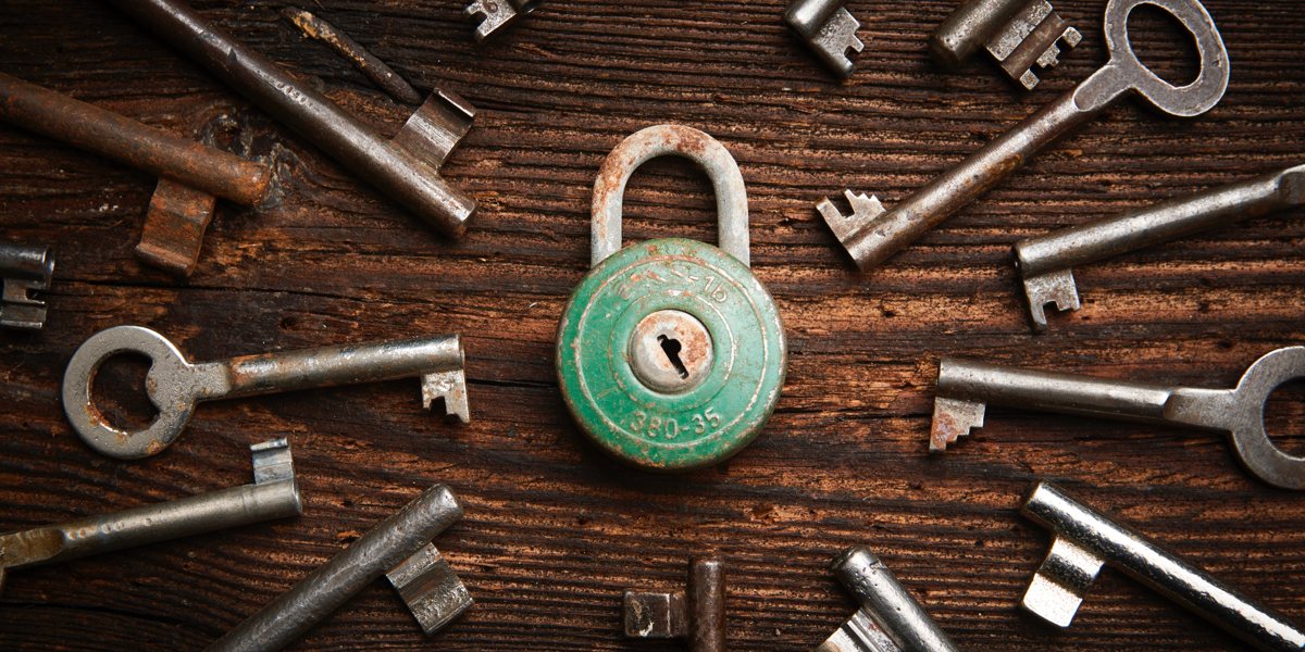 a rusty green lock surrounded by many different keys