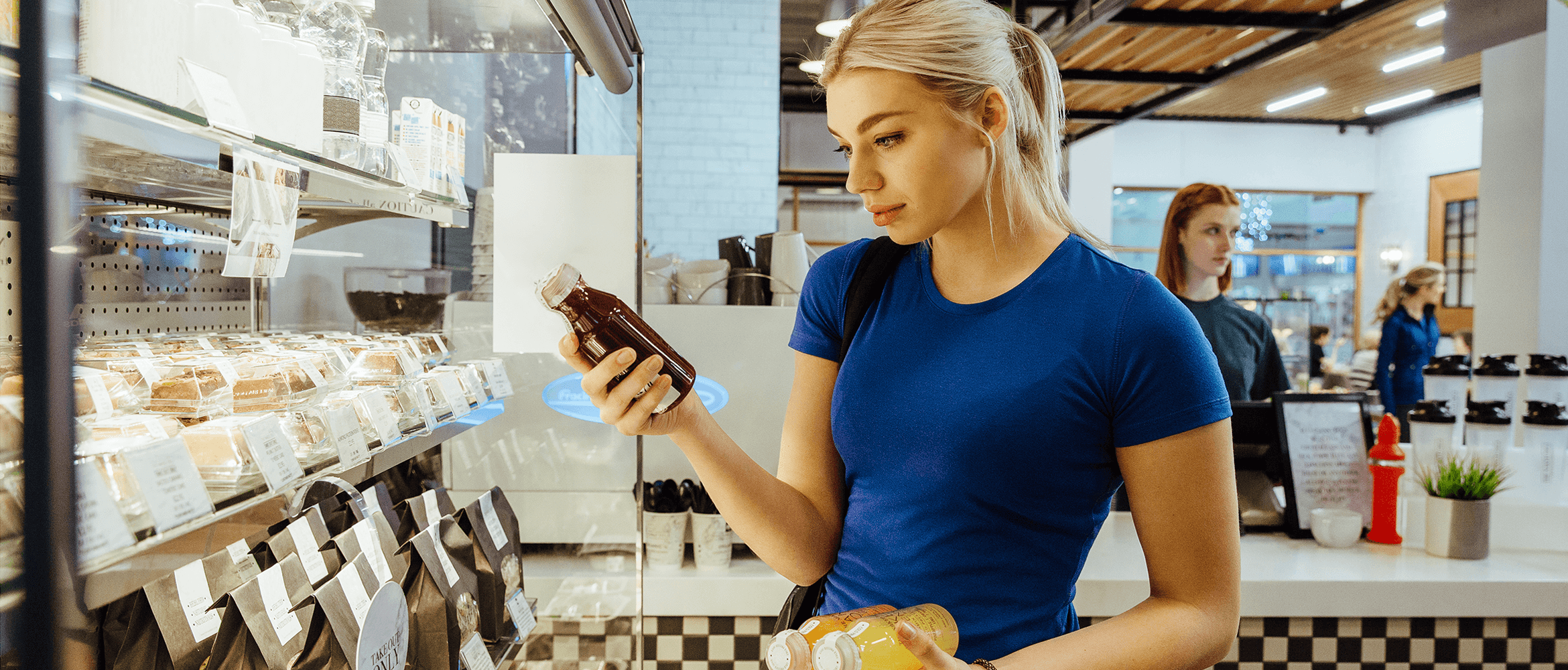 a woman in a cafe looking at a drink's ingredient list