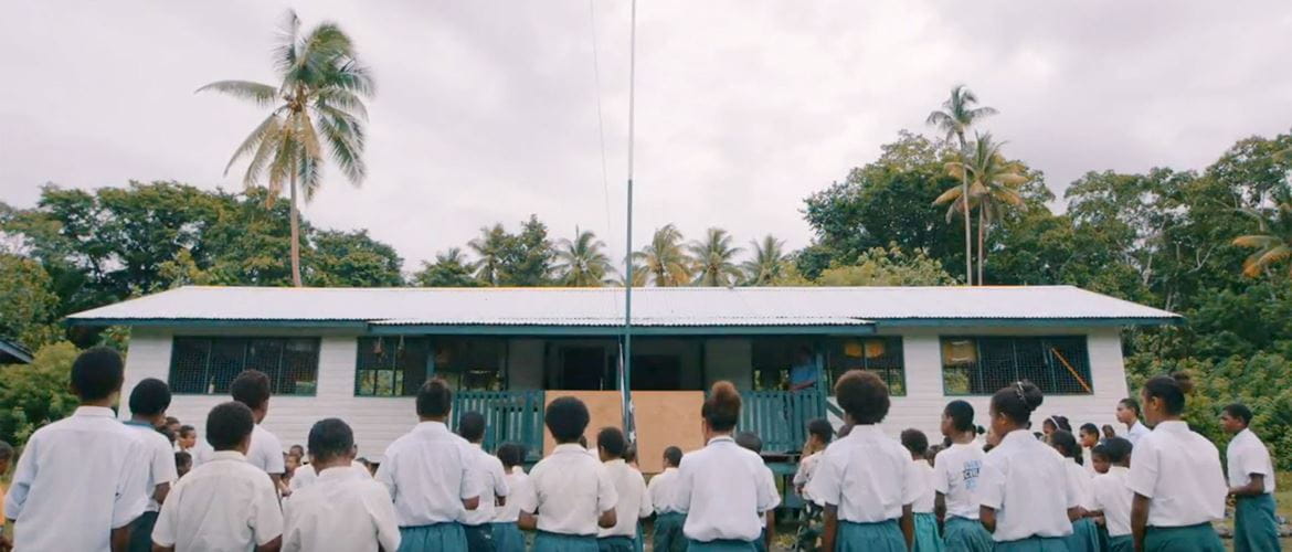 Children wearing uniforms in front of the school