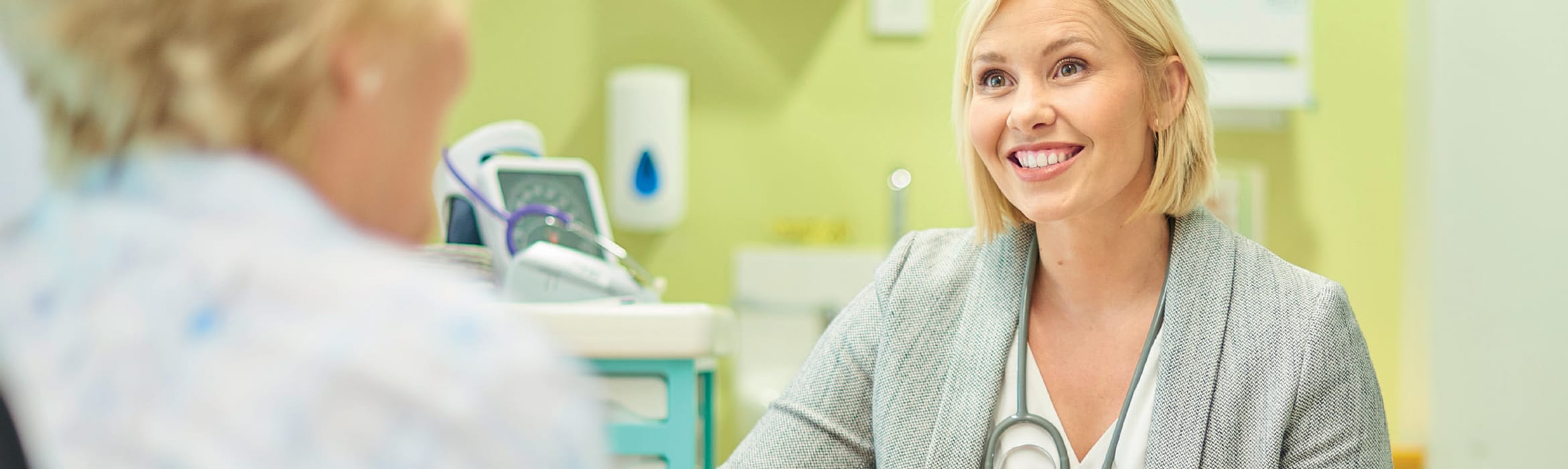 A female GP talking to a female patient in a doctor's surgery room