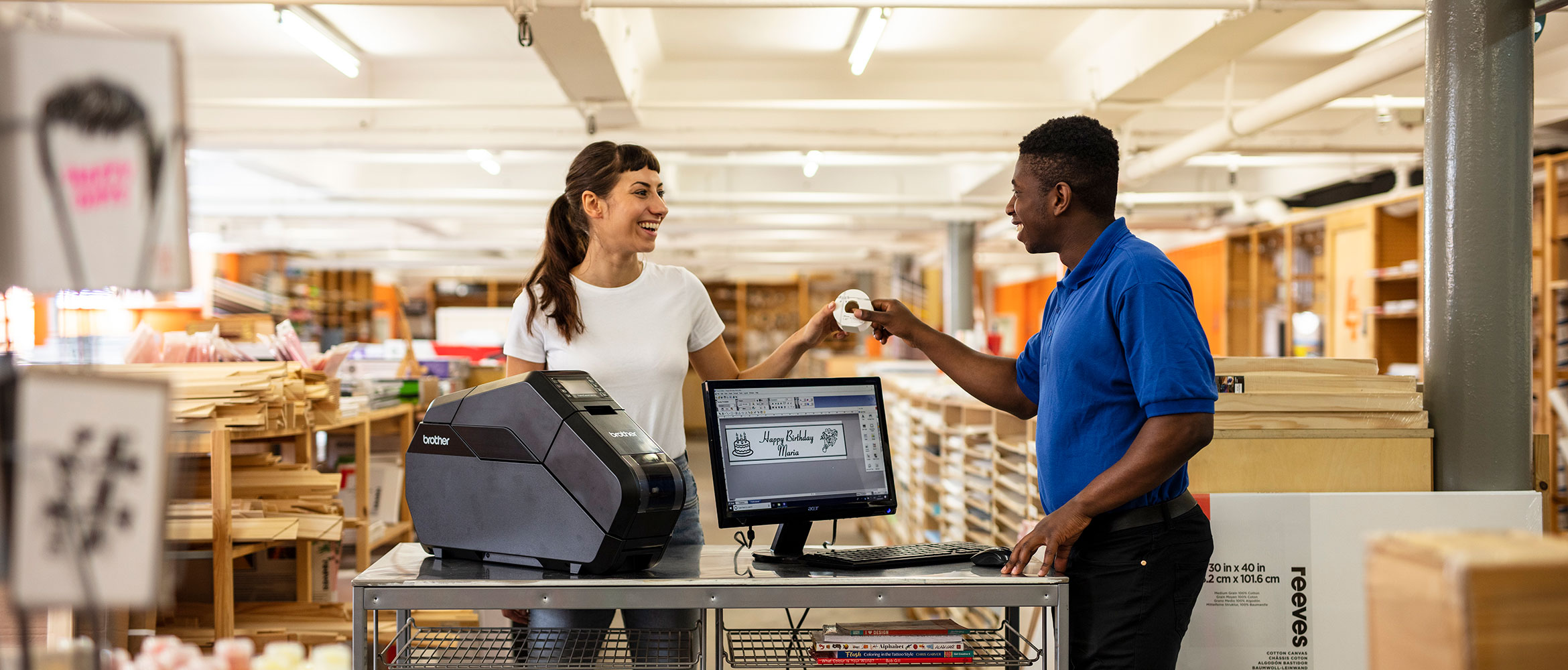 A worker passes a customised ribbon to a customer, that was created on the Brother Tape Creator Pro