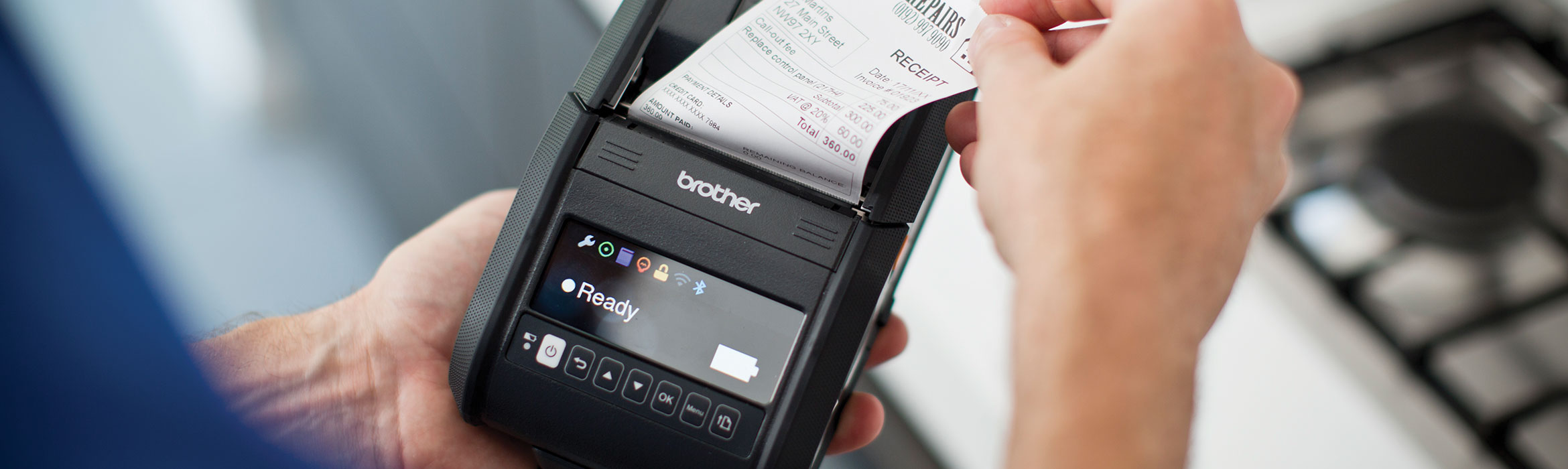 Man removing receipt from Brother handheld mobile printer