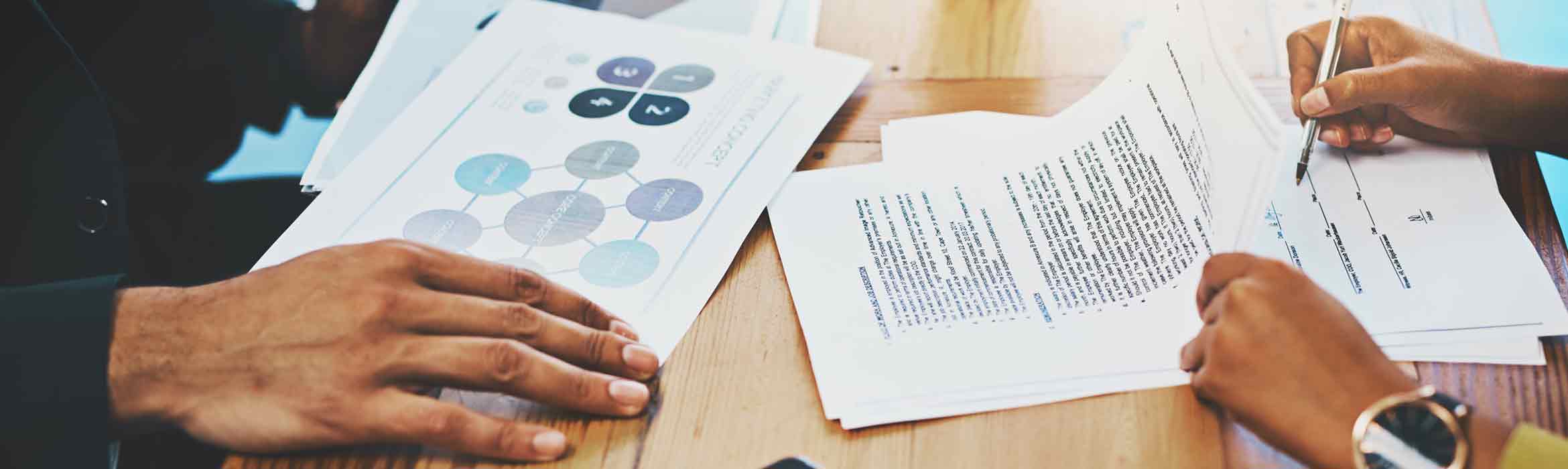 Cropped shot of a man and woman completing paperwork together at a desk