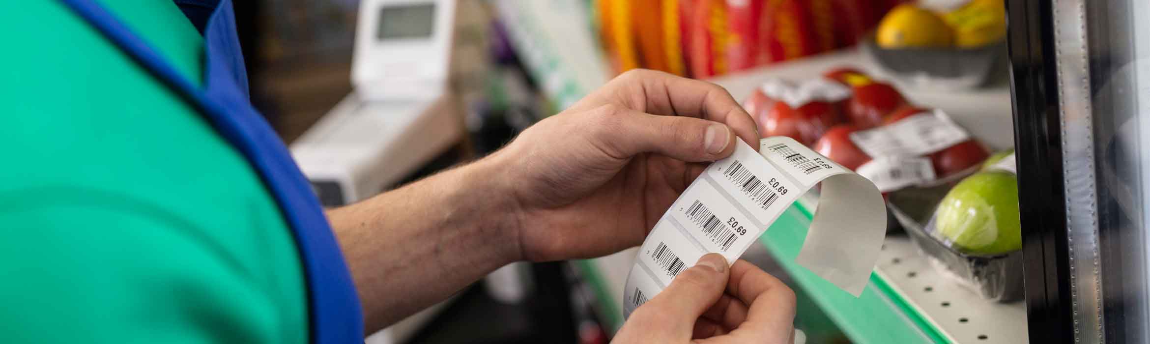 Supermarket worked labelling items on a shelf using a Brother TD machine