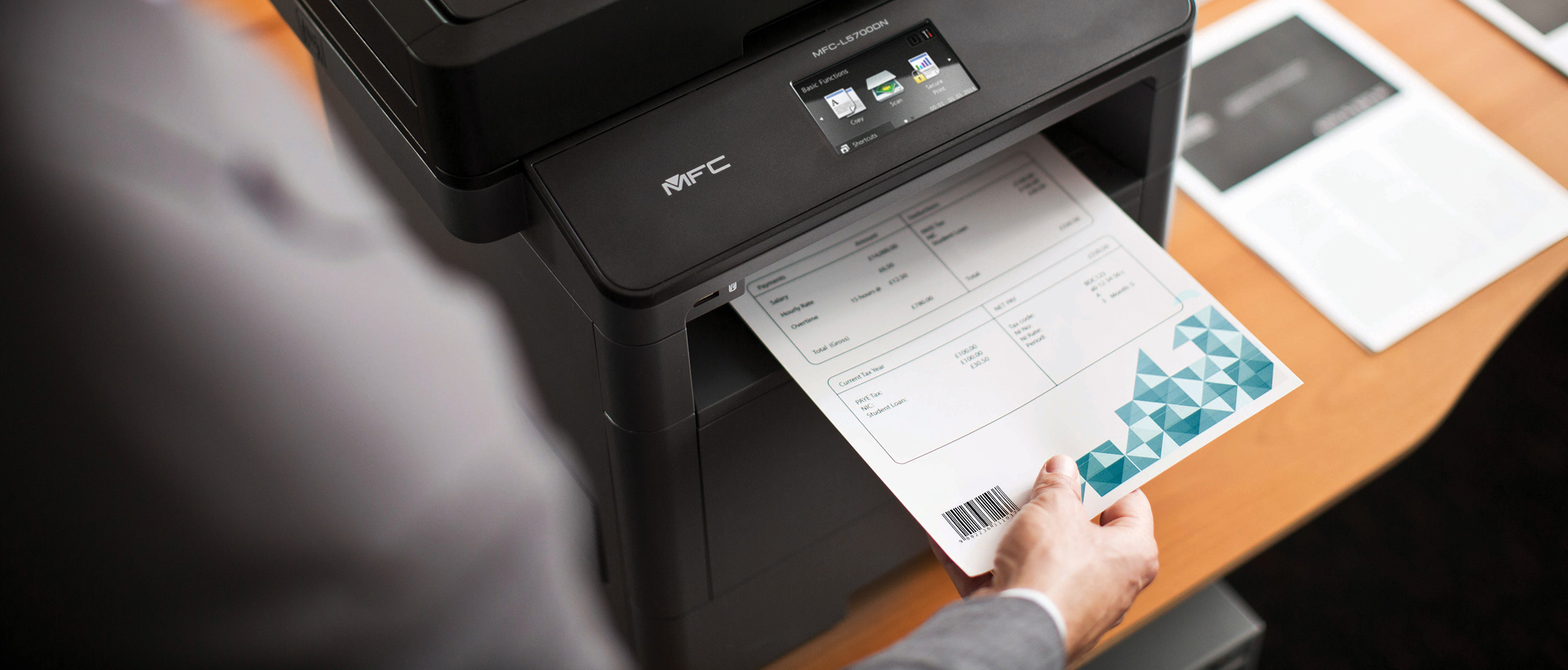 An over the shoulder view of a suited man removing a freshly printed piece of paper with a barcode on it from a Brother printer
