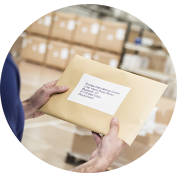 a warehouse employee holding an envelope with a printed label