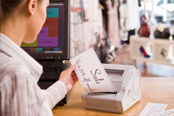 Shop worker printing a large sale sign on a continuous label and TD-4000 series label printer
