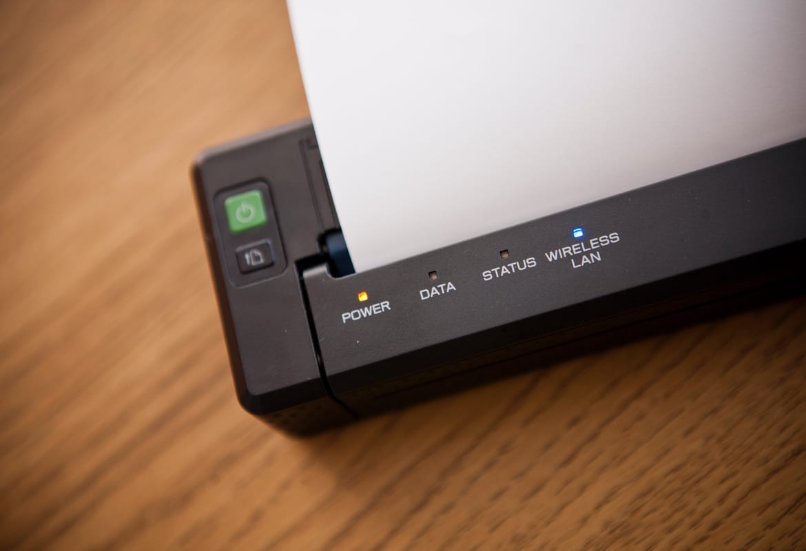 Close-up of a Brother PJ Series tattoo printer on a wooden surface