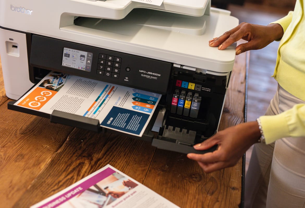 Close-up of a lady opening the supplies door of an inkjet printer after printing colour documents