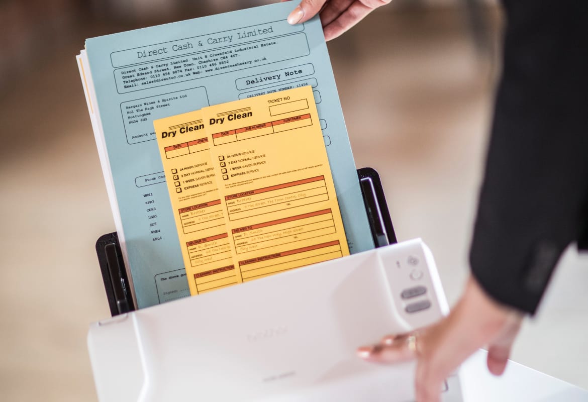 Close-up of a lady using a Brother sheetfed scanner to scan multiple documents