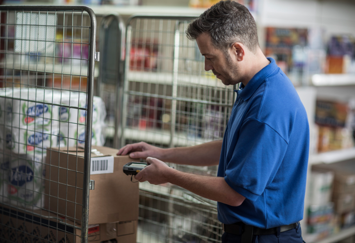 A man using a mobile printer in a warehouse environment