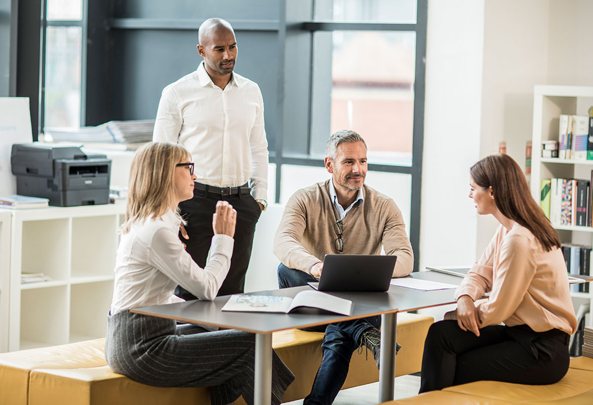 Group of people in an office with mono laser printer in background