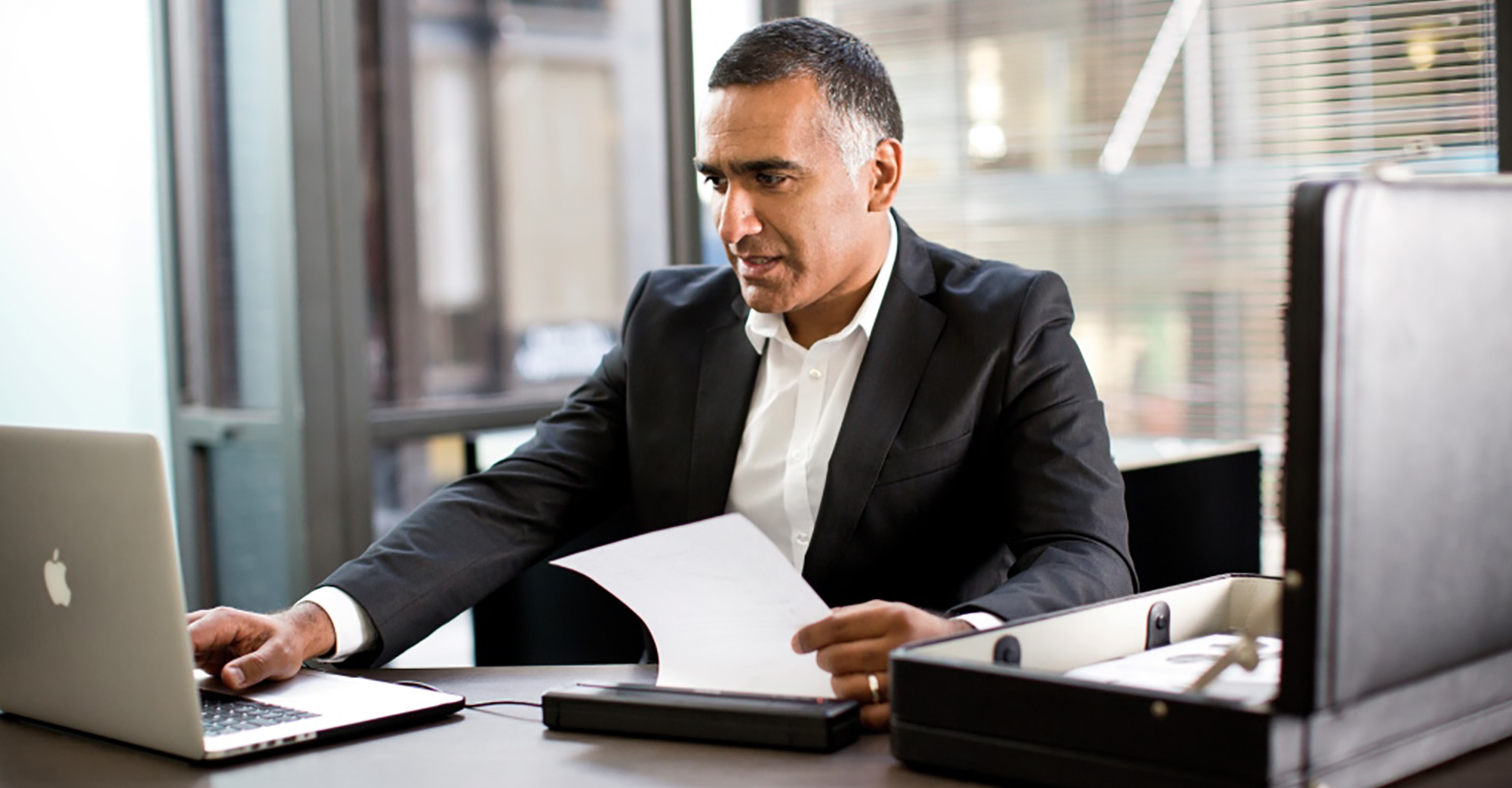 Businessman printing a document from a laptop computer to a PocketJet mobile printer in an office environment