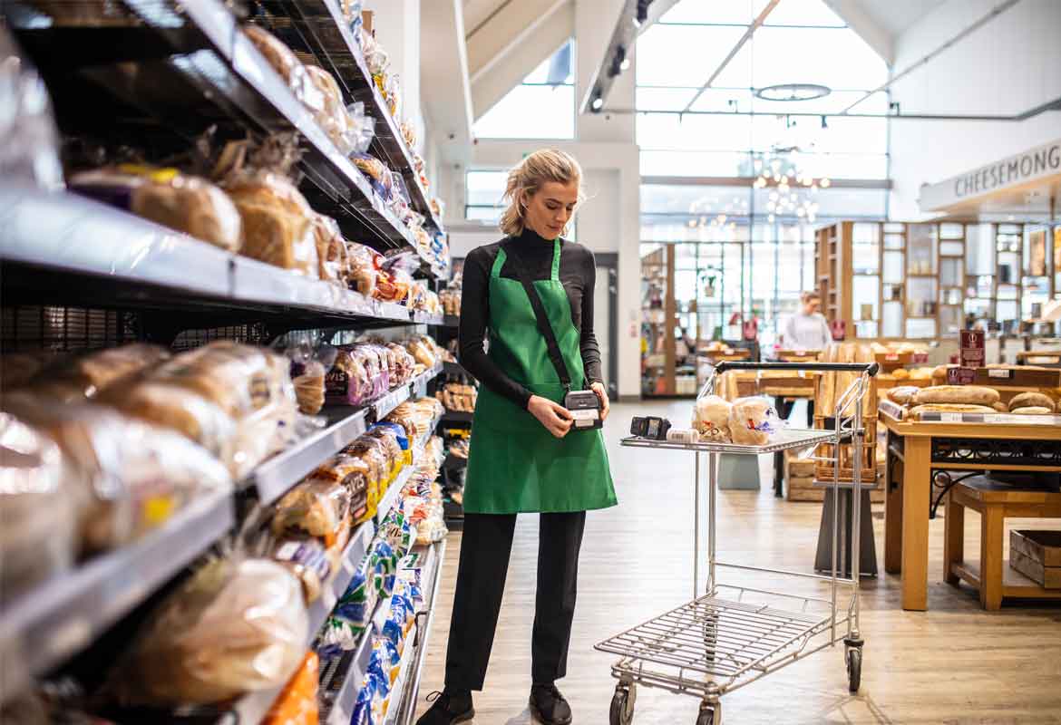 A supermarket worker using a Brother mobile labelling device on the bread aisle