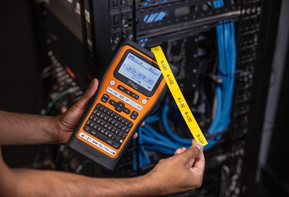Electrician applying printed tape to electrical equipment