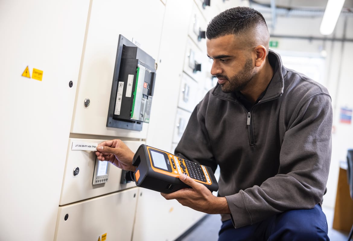 Electrician removing printed tape from a handheld label printer