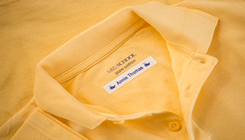 Yellow school polo shirt with a name label 