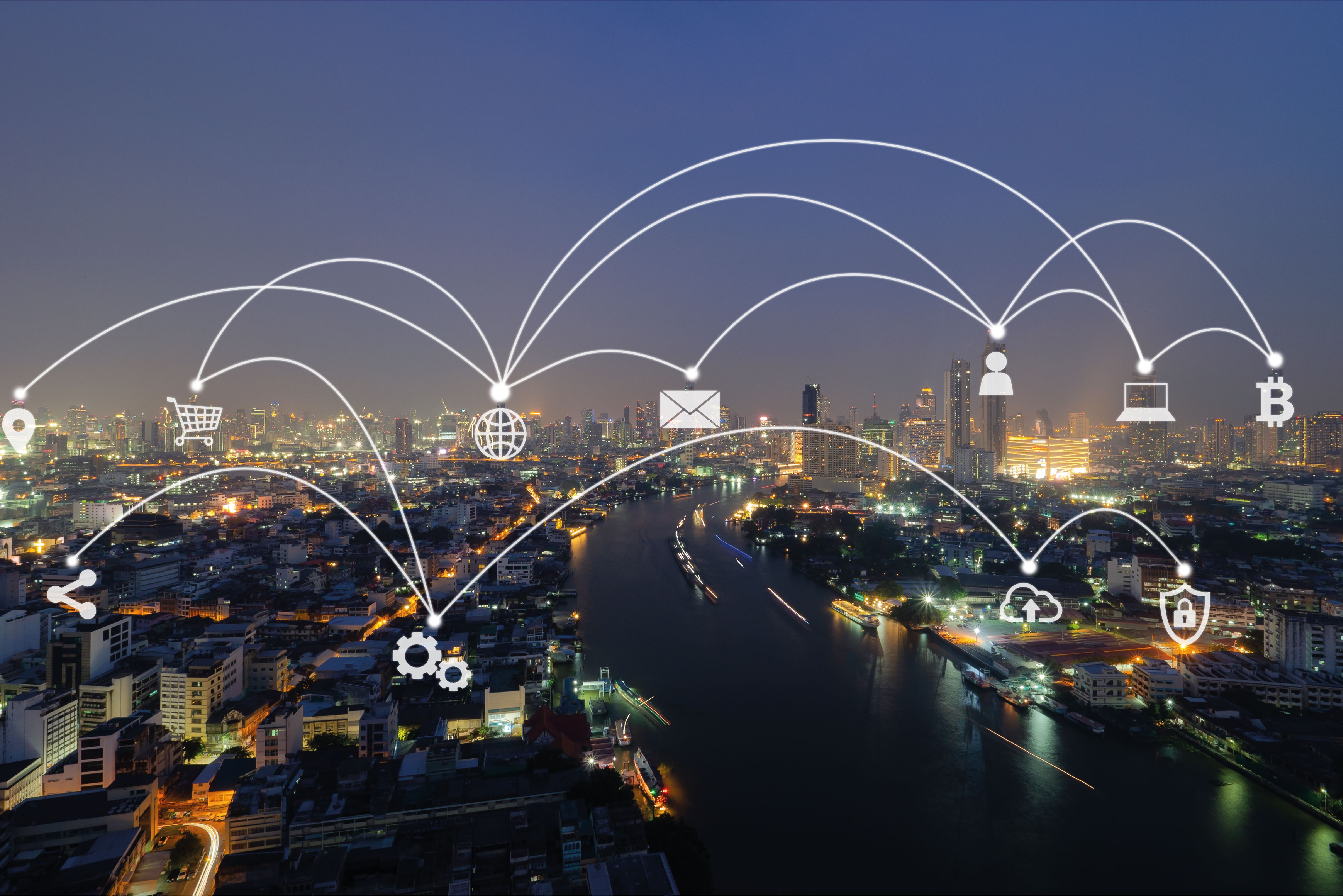Photograph of a cityscape that is interconnected by icons such as a laptop, letter, a cloud, and cogs