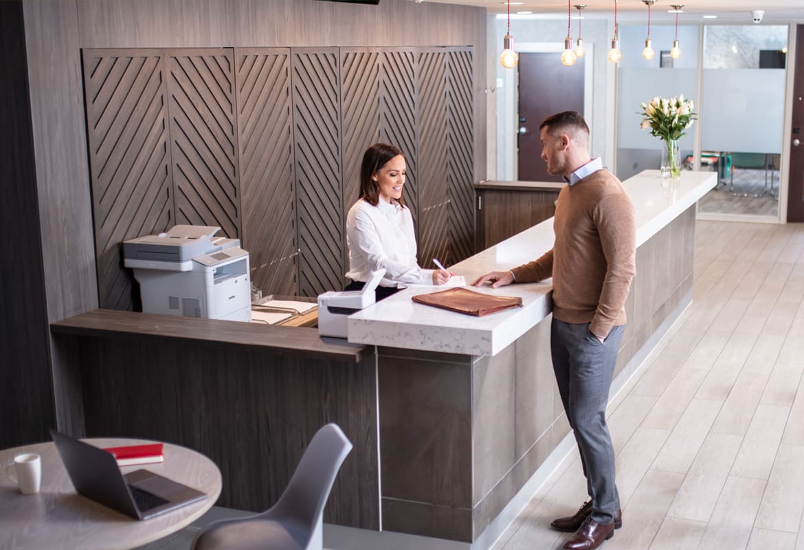 Store staff member talking with customer in hotel environment