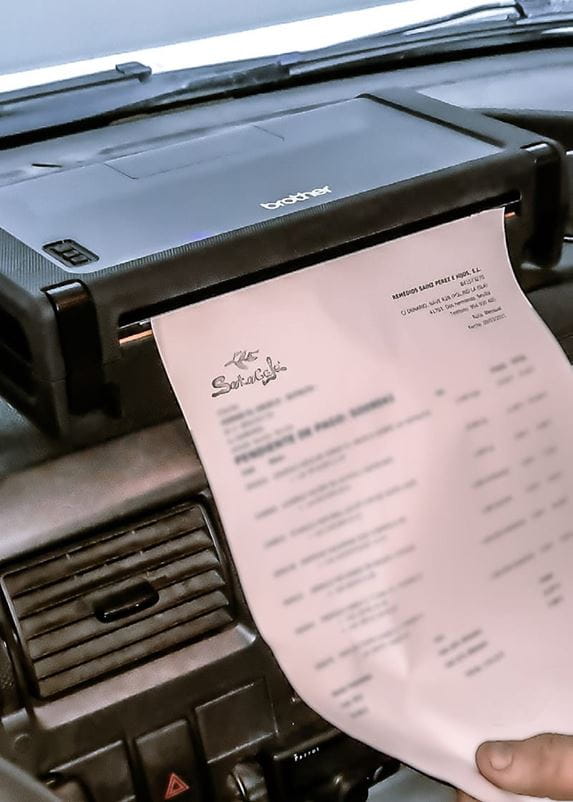 Sales person printing an invoice on a Brother PJ-762 mobile printer, installed on the dashboard of a Soto Café field sales vehicle