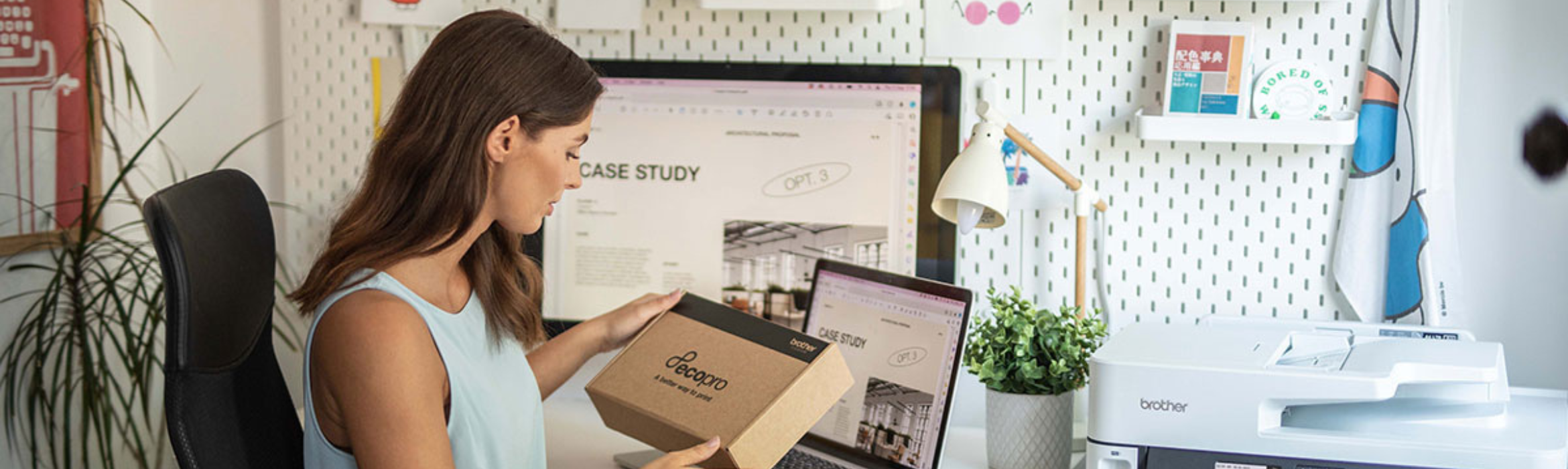Lady sat at her computer looking at a box of EcoPro ink and toner as part of the subscription