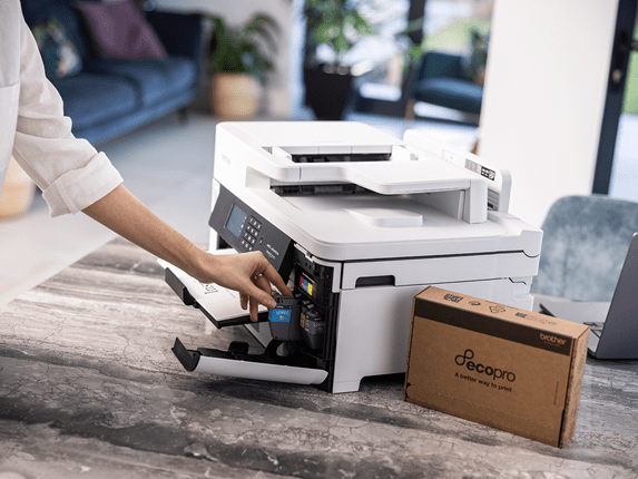 A woman putting Brother cartridges from an EcoPro subscription into her Brother printer 