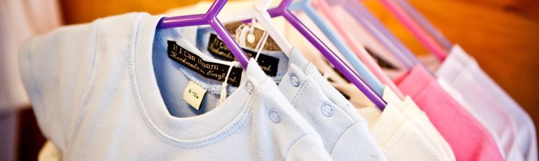 Rail of clothes in a shop showing labels printed with a Brother label printer