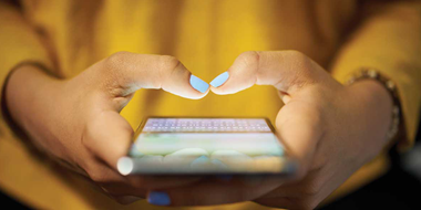 Woman holding a smartphone with her fingers poised over the screen