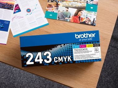 Overhead view of a Brother TN-243CMYK toner pack on a table alongside printed documents