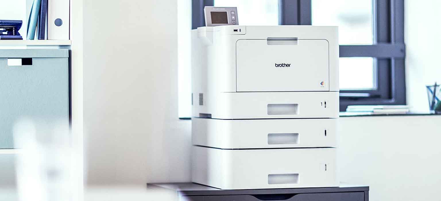 A Brother printer sat on top of a cabinet in an office