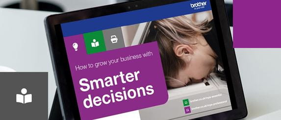An upright tablet device on a white desk with the front cover of the 'How to grow your business with smarter decisions' guide on the display