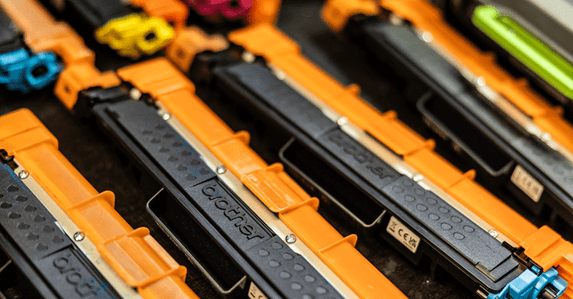 3 Brother black and orange toner cartridges in a row