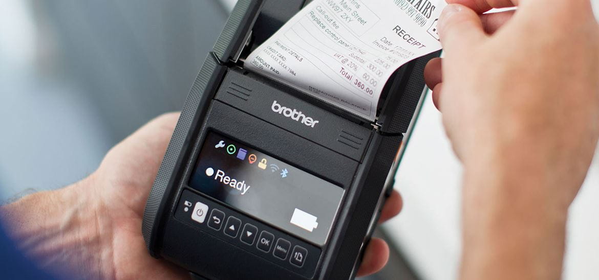Person removing receipt from a handheld Brother mobile printer
