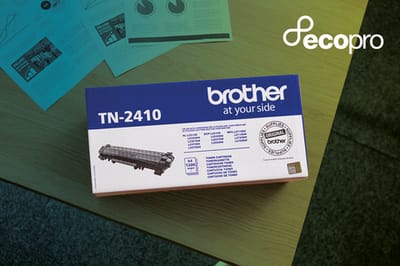 Brother toner cartridge carton on tabletop alongside black and white printed documents