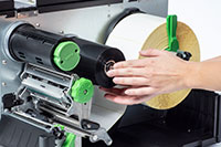 Thermal ribbon being rolled inside Brother industrial label printer