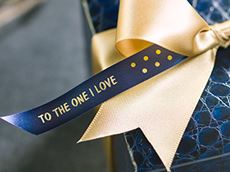 Satin ribbon with gold writing on navy blue ribbon printed on a Brother P-touch CUBE Plus label printer