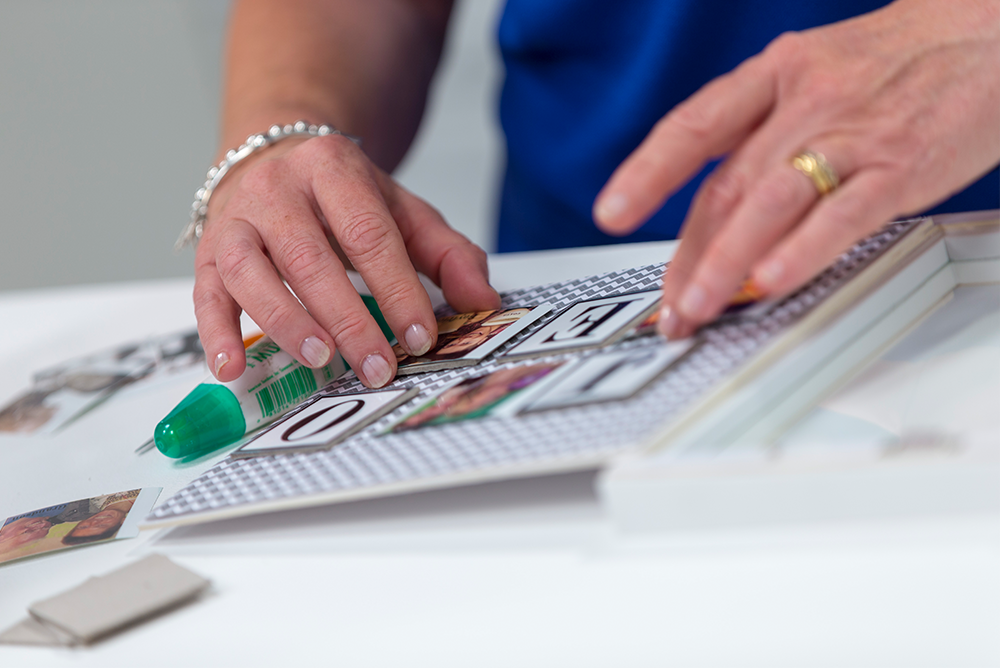 Close-up of a woman placing items in a photo frame