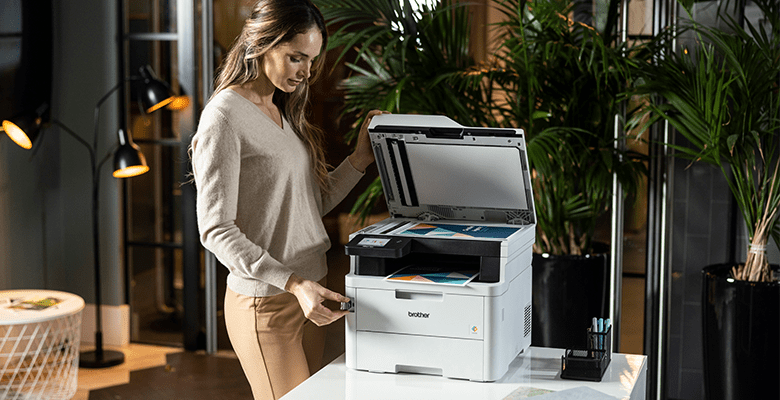 A woman using a multifunction printer to scan a document in an SMB environment