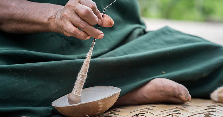 Close up of a male crushing a pot in an outdoor setting on a beige mat