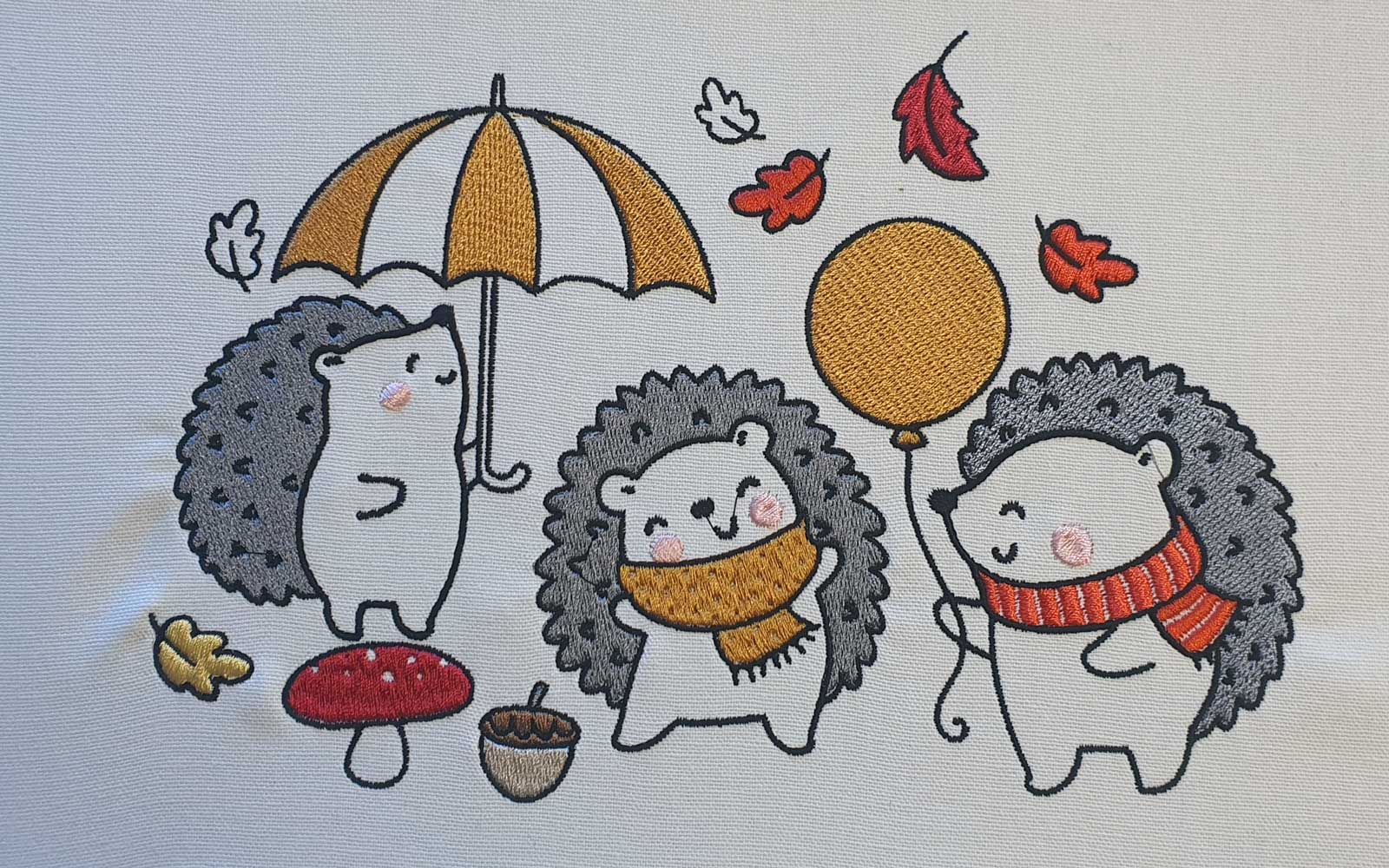 Three embroidered autumn hedgehogs