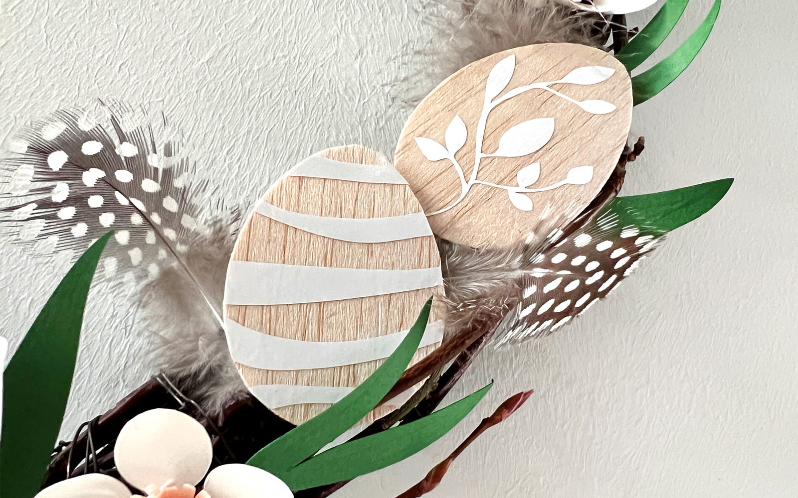close up of small balsa wood eggs with white vinyl decal on